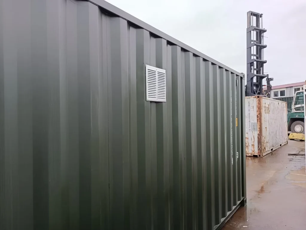 Container-Außenansicht mit eingesetztem Lüftungsgitter an der Seitenwand für verbesserten Luftaustausch.